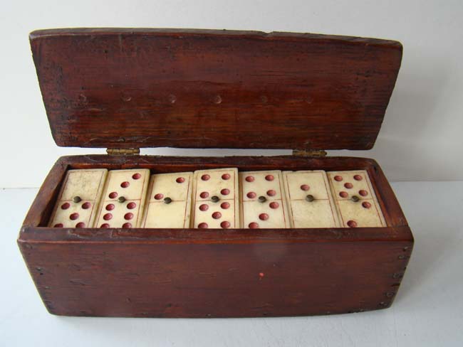 An early 19th century boxed set of bone dominoes with red dots circa 1825.